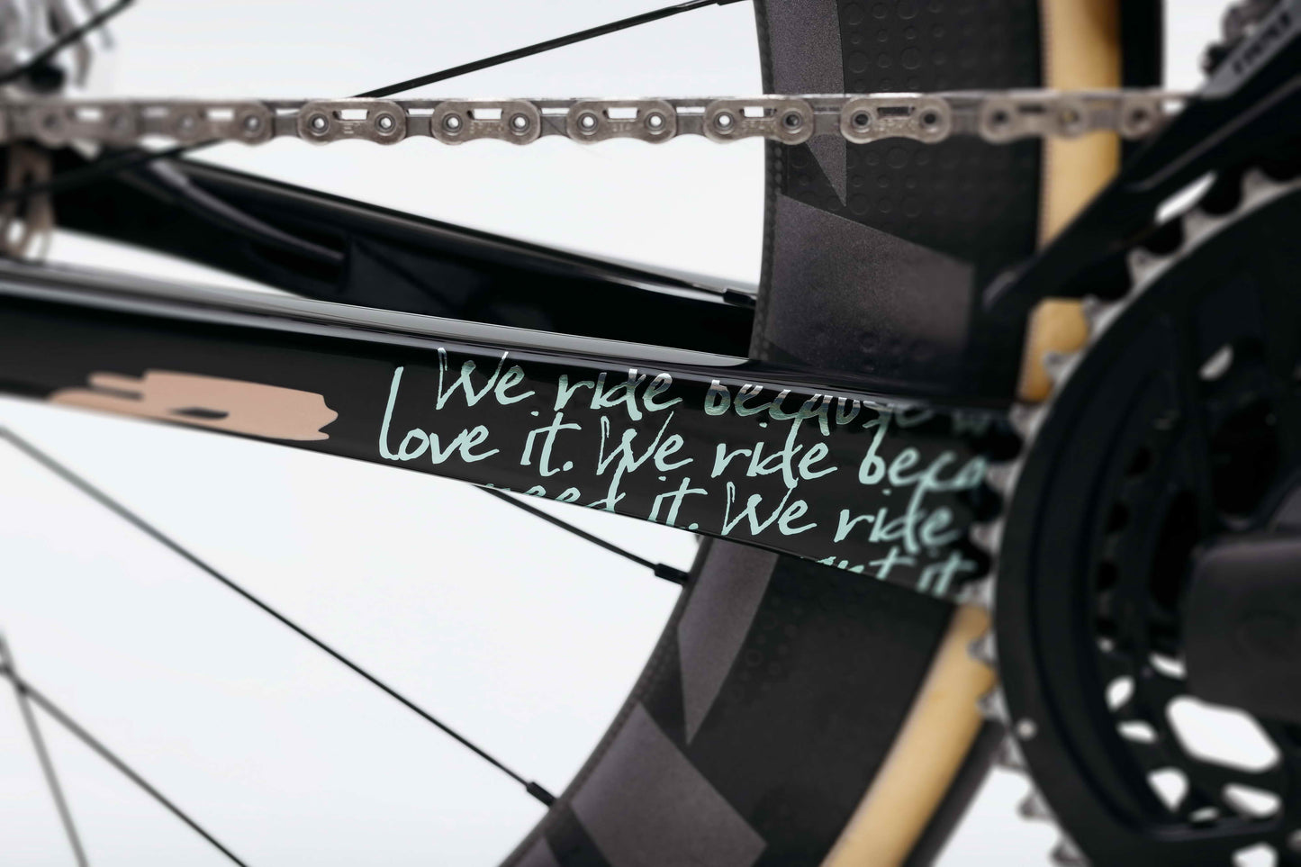 Close-up of a Haro Bikes Partimos Carbon Frameset “Grid” and chain with handwritten text: We ride because we love it, repeated.