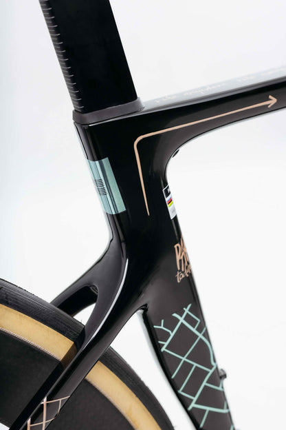 Close-up of a Haro Bikes Partimos Carbon Custom "Grid" frame with geometric patterns and rear wheel on a white background.