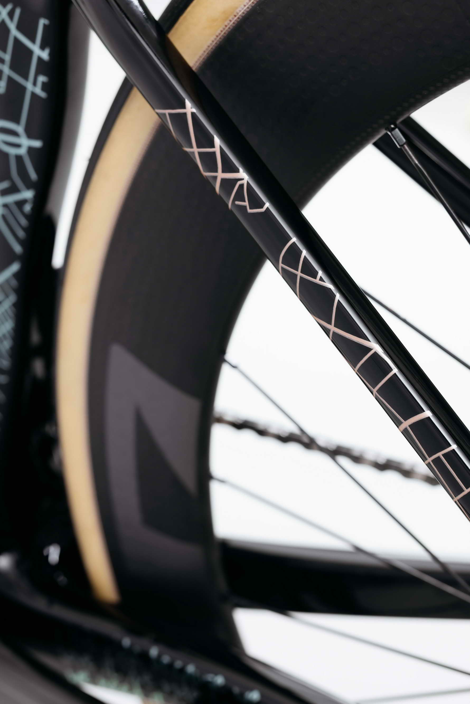 Close-up of Haro Bikes' Partimos Carbon Custom "Grid" rear wheel, tan sidewall tire, and geometric frame patterns.