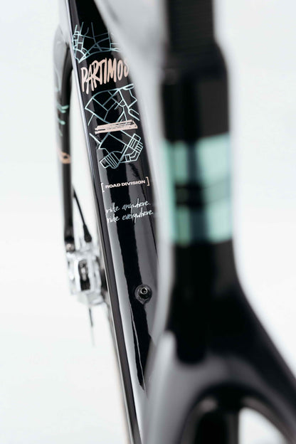 Close-up of a black Haro Bikes Partimos Carbon Frameset “Grid” with turquoise, white graphics and the words “ride anywhere, ride everywhere.”.