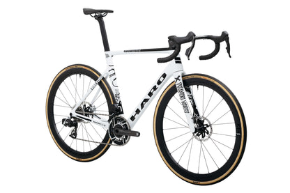Haro Bikes Partimos Carbon Custom "Black Sheep" road bike with drop bars, tan tires, rear view, on white background.