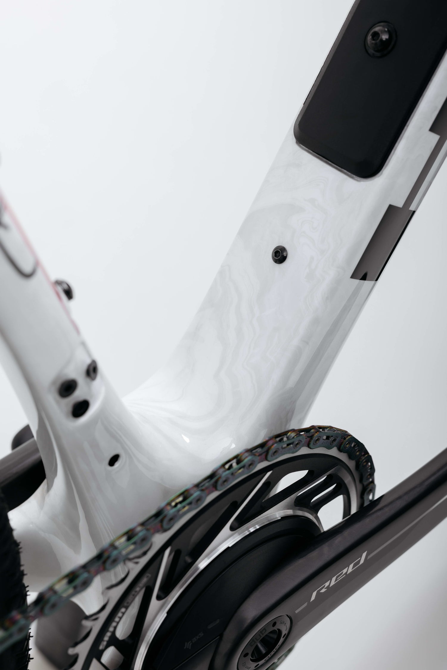Close-up of Haro Bikes’ Buzzard Carbon Custom “Desert Sunset” gravel frame, chainring, and crank arm with a clean, modern design.