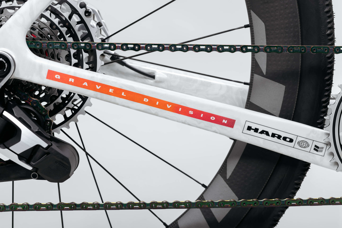 Close-up of the Buzzard Carbon Custom “Desert Sunset” by Haro Bikes, showing rear wheel, chain, and frame with branded detailing.