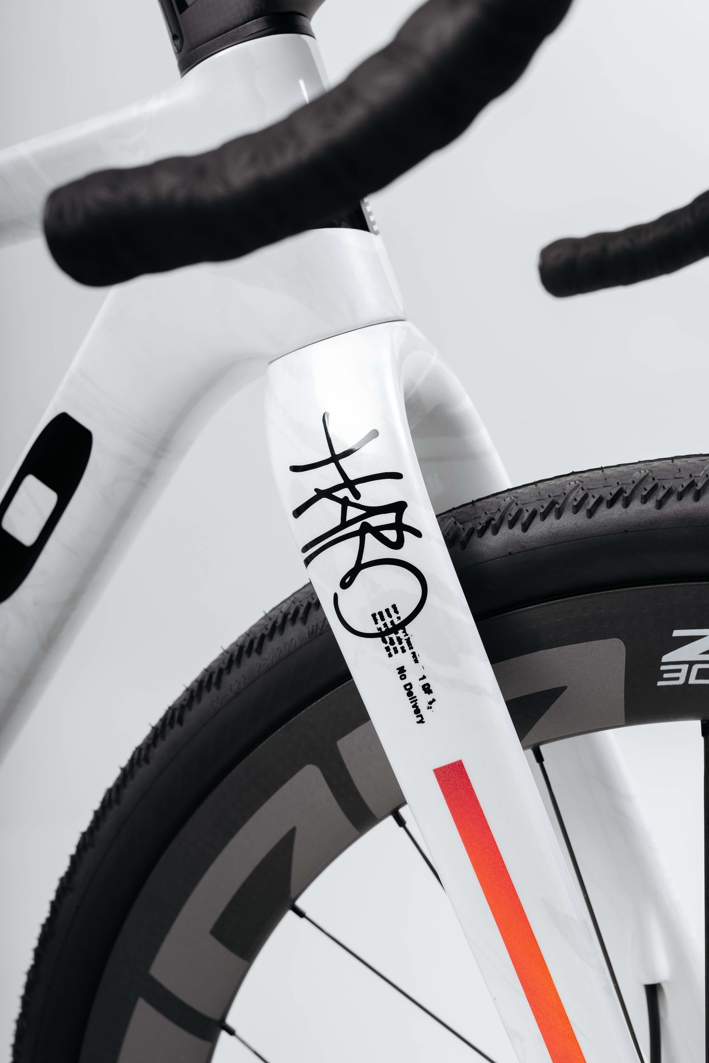 Close-up of a Haro Bikes Buzzard Carbon Custom “Desert Sunset” fork with black/red graphics, showing the front tire and handlebars.