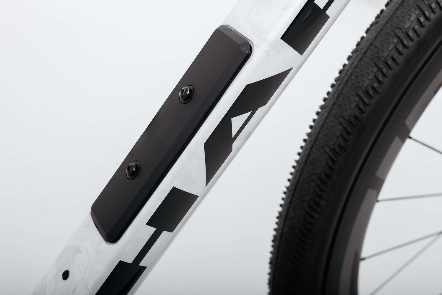 Close-up of a Haro Bikes Buzzard Carbon Custom “Desert Sunset” frame with black patterns, showing tire and accessory.