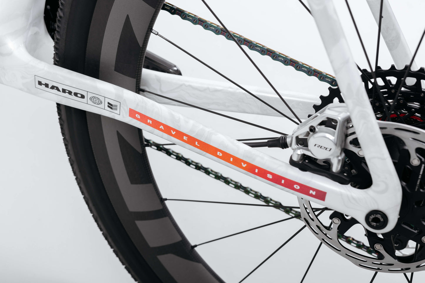 Close-up of Buzzard Carbon Custom “Desert Sunset” by Haro Bikes, showing rear wheel, disc brake, and Gravel Division carbon frame.