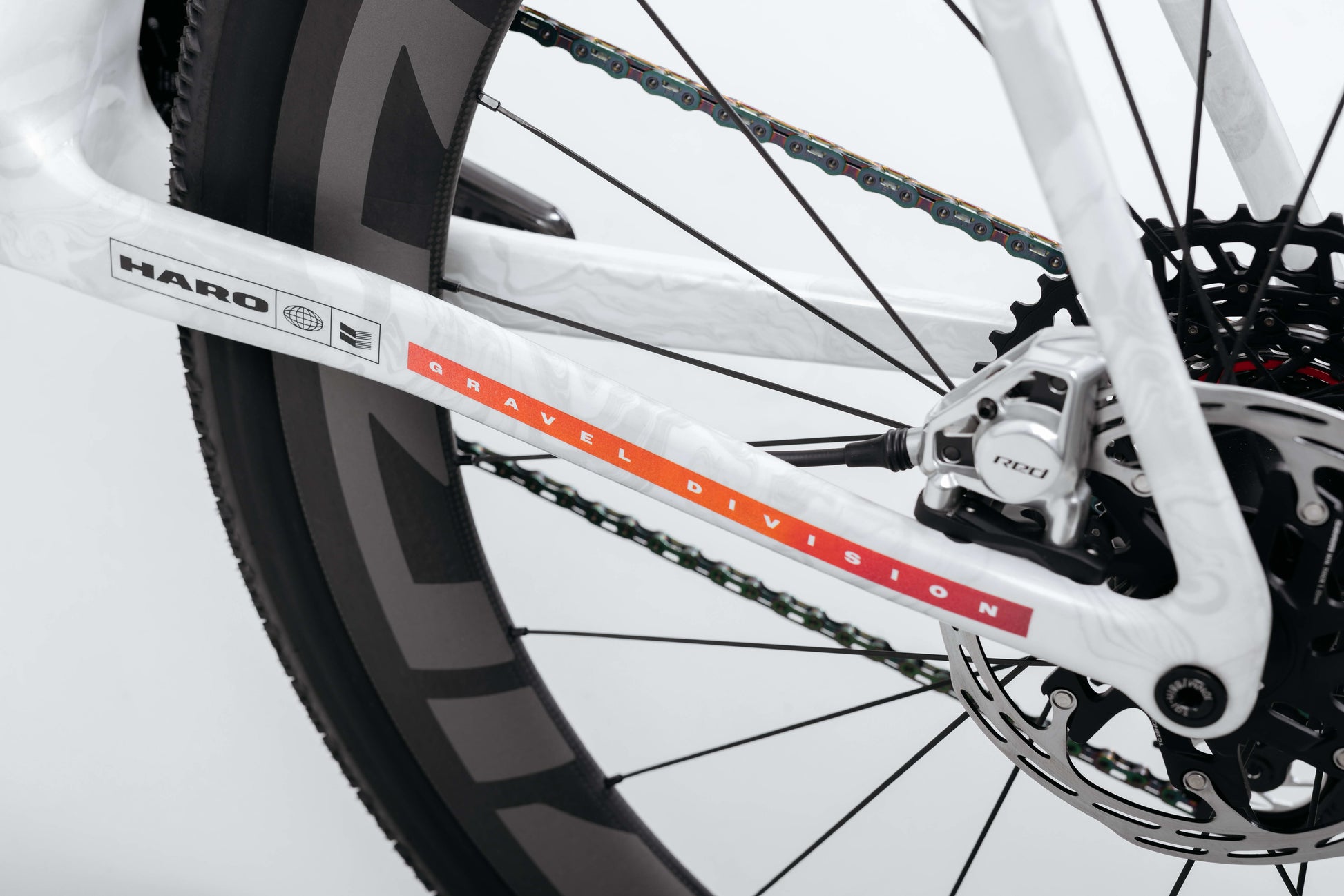 Close-up of Buzzard Carbon Custom “Desert Sunset” by Haro Bikes, showing rear wheel, disc brake, and Gravel Division carbon frame.