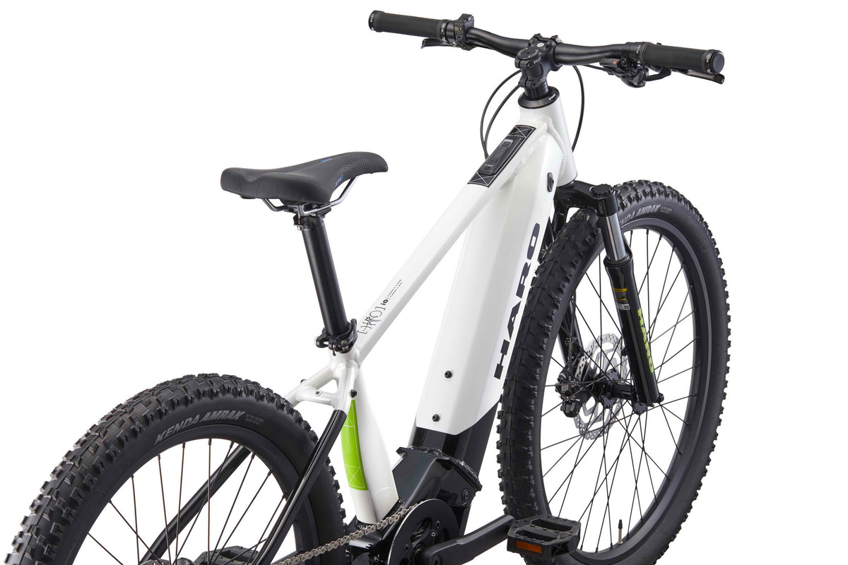 A white Haro Bikes eKids I/O 24/26 E-Bike for youth with thick tires and front suspension, shown from the rear.