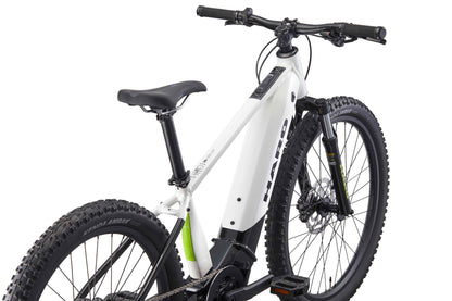 A white Haro Bikes eKids I/O 24/26 E-Bike for youth with thick tires and front suspension, shown from the rear.