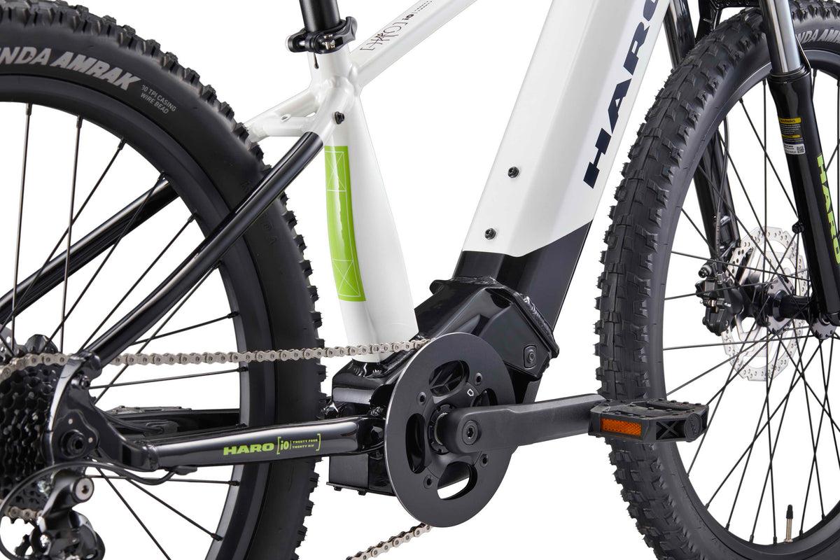 Close-up of the drivetrain and frame of a white Haro Bikes eKids I/O 24/26 with thick treaded tires and Bosch Performance Line SX Motor.