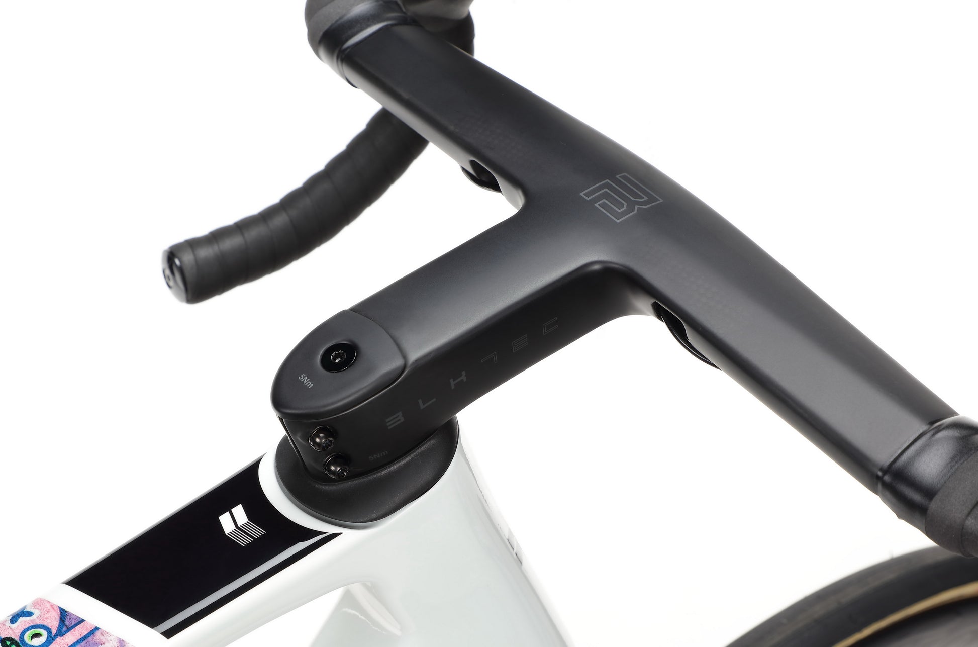 Close-up of a black handlebar with integrated stem on a Haro Bikes Rivette Carbon EP Edition white frame.