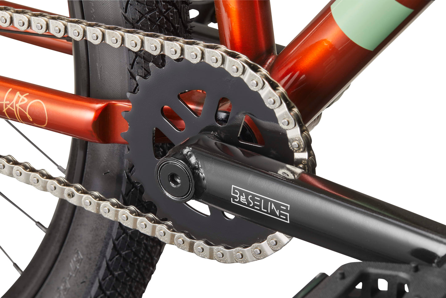 Close-up of a HARO Steel Reserve TS crankset, chainring, and chain on a red frame with a black Baseline crank arm.