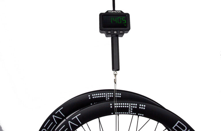 A Bike Beat Überflieger Pro 50 Disc carbon bicycle wheelset hanging from a digital scale reading 1.405 kilograms.