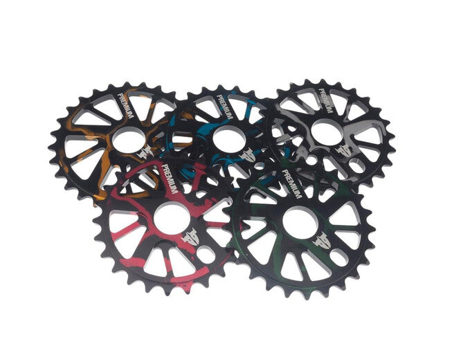 A cluster of five colorful PREMIUM GNARSTAR KETTENBLATT sprockets from 7075-T6 Aluminium on a white background.